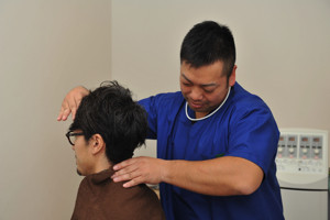 膝の触診をする女性スタッフ