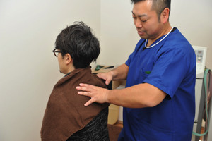 首を施術をするスタッフ